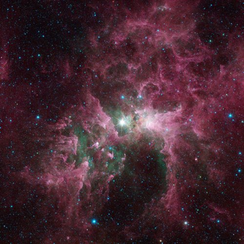 Fig.3. Vue en infrarouge de l’étoile Eta Carina entouré des nuages stellaires de la nébuleuse Carina. La vue prise par le télescope spatial Spitzer montre, en rouge les poussières, en vert les nuages de gaz très chauds. Cette étoile géante (100 fois la masse du soleil) émet une lumière laser dans l’ultraviolet. Crédit NASA. 